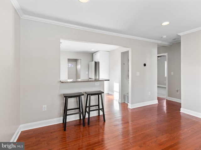 interior space with dark hardwood / wood-style flooring and crown molding