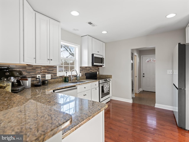 kitchen featuring sink, white cabinetry, tasteful backsplash, appliances with stainless steel finishes, and dark hardwood / wood-style floors