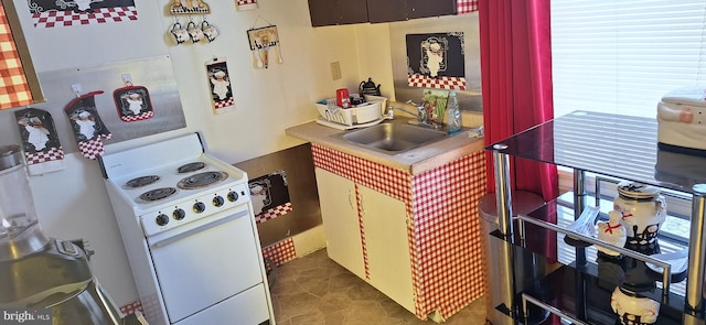 kitchen featuring sink, electric range, and dark tile patterned flooring