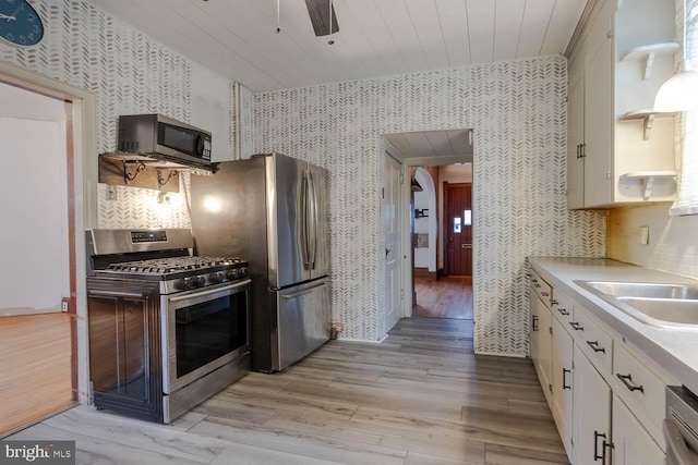 264 S Main St, Pleasant Gap, PA 16823 - kitchen featuring white cabinetry, appliances with stainless steel finishes, light wood finished floors, and wallpapered walls