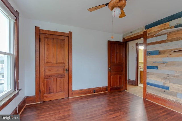 264 S Main St, Pleasant Gap, PA 16823 - unfurnished bedroom featuring baseboards, wooden walls, and wood finished floors
