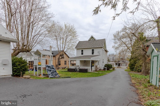 264 S Main St, Pleasant Gap, PA 16823 - back of house featuring a lawn, a residential view, a playground, and covered porch