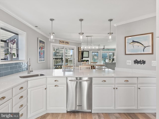 kitchen featuring sink, white cabinets, hanging light fixtures, ornamental molding, and light hardwood / wood-style flooring