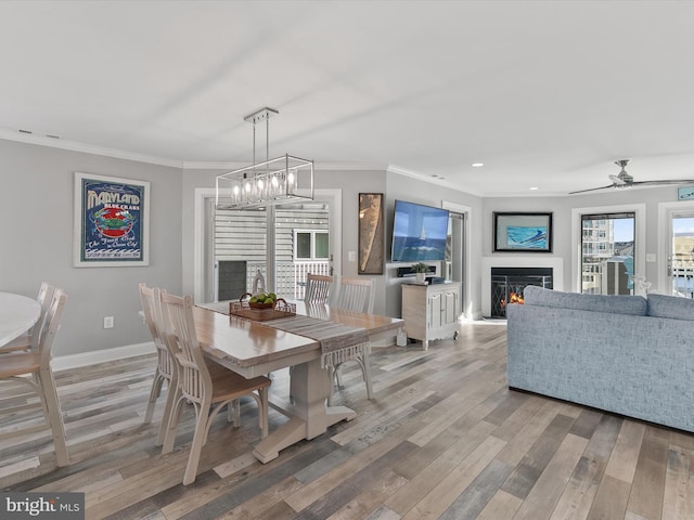 dining area with wood-type flooring and ornamental molding