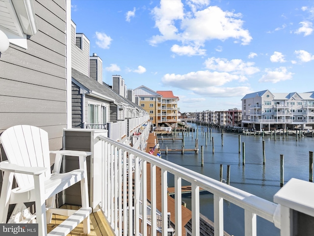 balcony with a water view and a boat dock