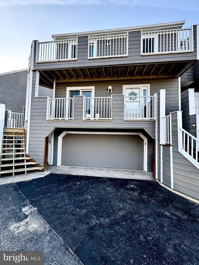 view of front of property featuring a balcony and a garage