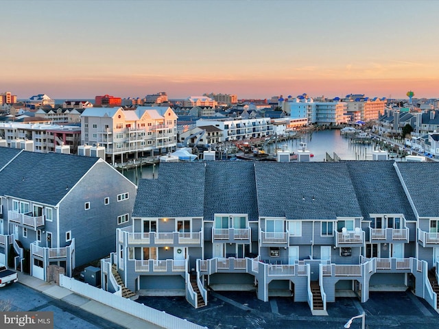 aerial view at dusk featuring a water view