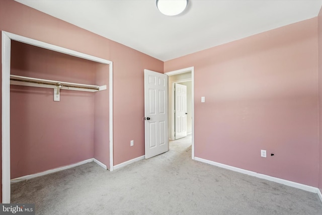 unfurnished bedroom featuring a closet and light carpet