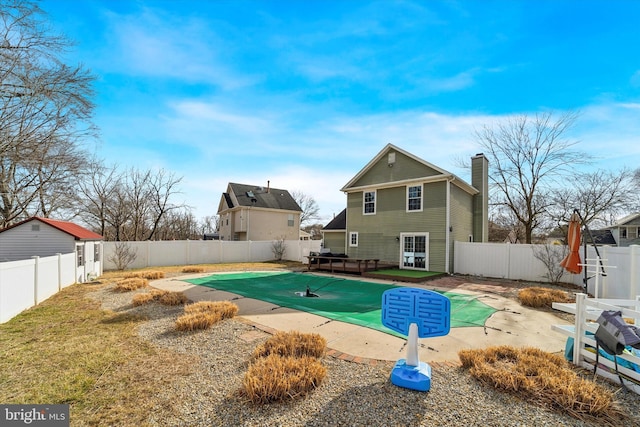 back of house with a hot tub and a patio