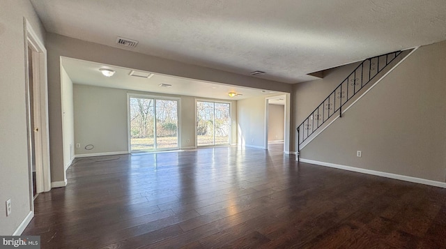 unfurnished living room featuring dark hardwood / wood-style floors and a textured ceiling