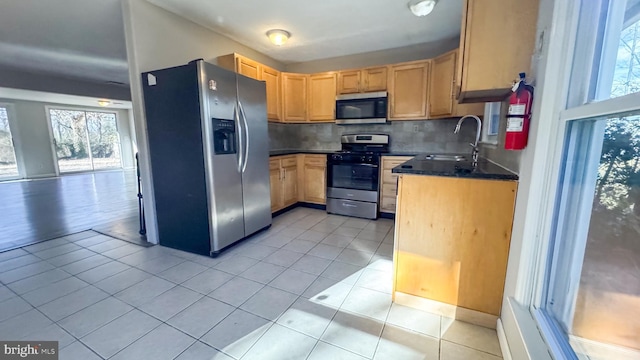 kitchen with light tile patterned flooring, stainless steel appliances, sink, and backsplash