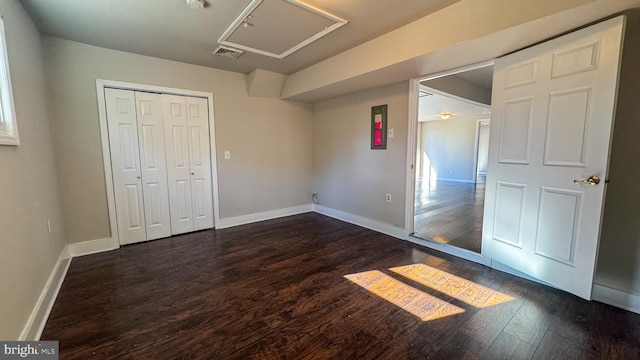 unfurnished bedroom featuring dark hardwood / wood-style flooring and a closet