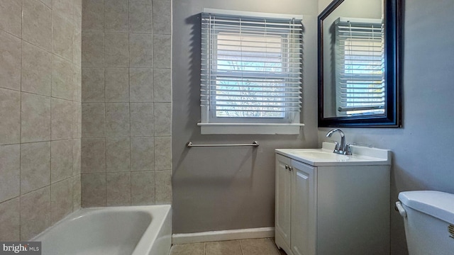 bathroom featuring vanity, tile patterned floors, a tub, and toilet