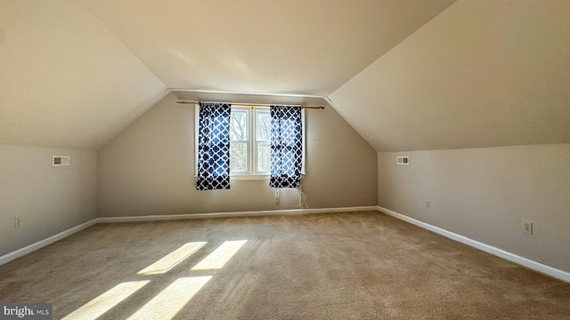 bonus room with light carpet and vaulted ceiling