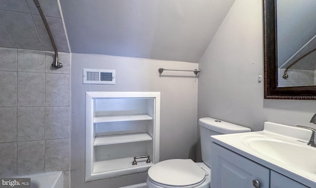 bathroom with vanity, lofted ceiling, toilet, and tiled shower