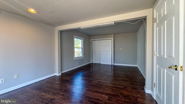 unfurnished bedroom featuring dark wood-type flooring and a closet