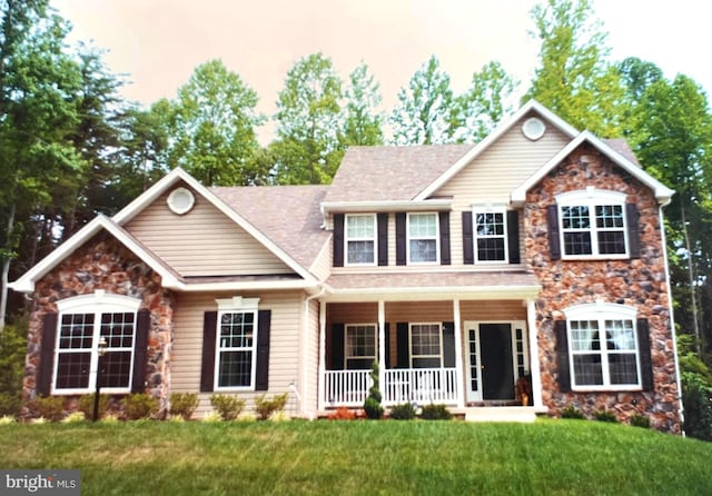 view of front facade featuring covered porch and a front yard