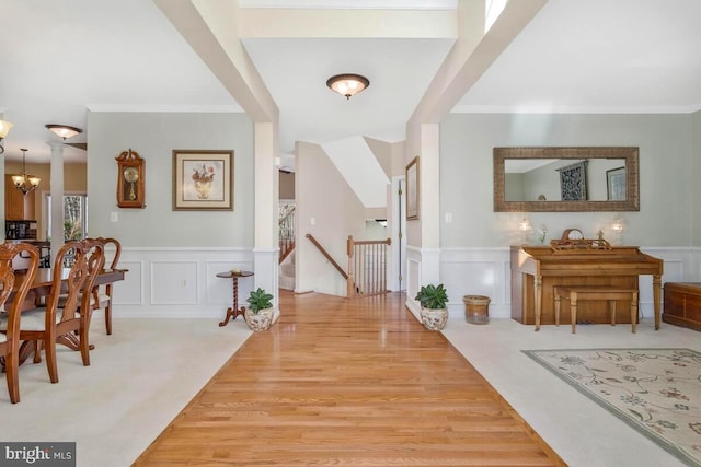 entryway featuring wainscoting, a notable chandelier, and a decorative wall