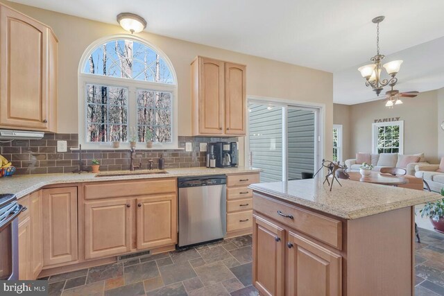 kitchen featuring visible vents, stone finish flooring, light brown cabinets, a sink, and dishwasher