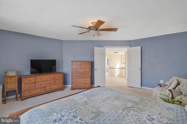 bedroom featuring light carpet, a ceiling fan, and baseboards