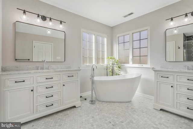 bathroom with two vanities, a soaking tub, visible vents, and a sink