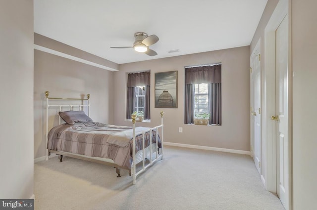 bedroom featuring light carpet, ceiling fan, visible vents, and baseboards