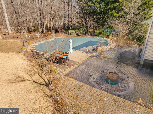 view of pool with a patio, fence, a fenced in pool, and a grill