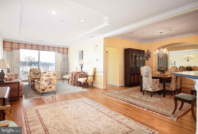 living room featuring hardwood / wood-style flooring, crown molding, and a chandelier