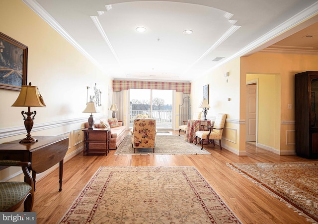 sitting room with crown molding and light hardwood / wood-style flooring