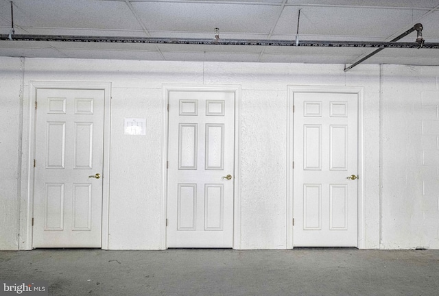 interior space with concrete flooring and a drop ceiling