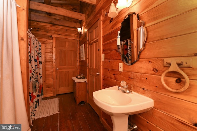 bathroom with hardwood / wood-style flooring and wood walls