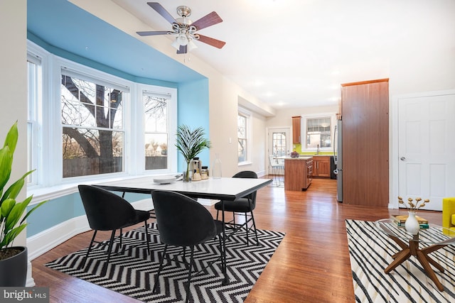 dining space with ceiling fan, sink, and light hardwood / wood-style floors