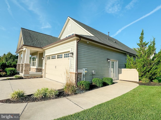 view of side of property featuring a garage and a yard