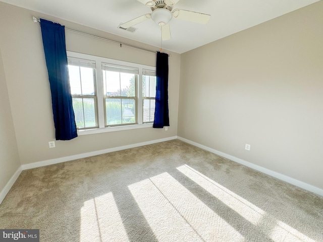 spare room with ceiling fan and carpet