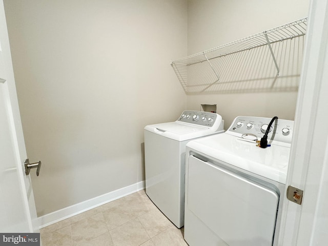 laundry area featuring washer and dryer and light tile patterned floors