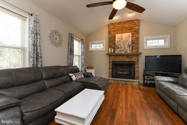 living room with a fireplace, a healthy amount of sunlight, dark hardwood / wood-style flooring, and vaulted ceiling