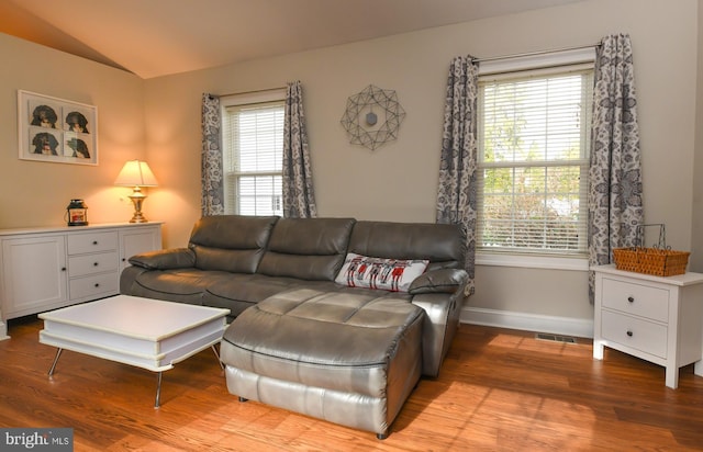 living room featuring vaulted ceiling and light hardwood / wood-style floors