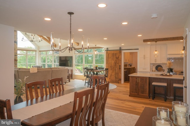 dining room featuring a barn door and light hardwood / wood-style floors