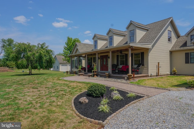 new england style home featuring a porch, a garage, and a front lawn