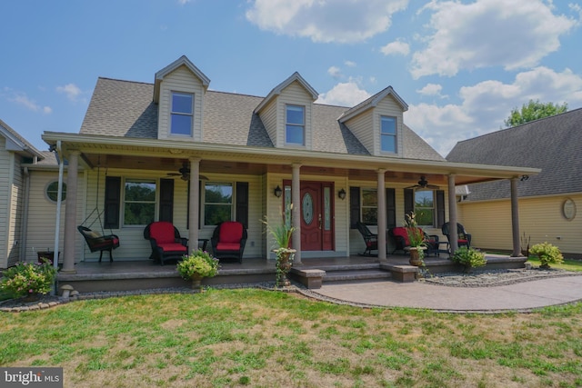 cape cod-style house featuring ceiling fan, a porch, and a front lawn