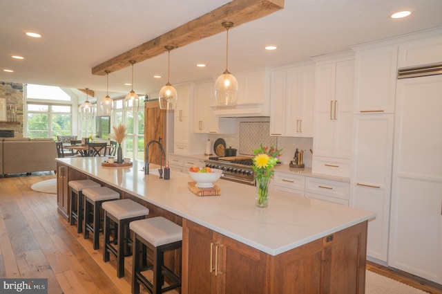 kitchen with white cabinetry, pendant lighting, backsplash, and a spacious island