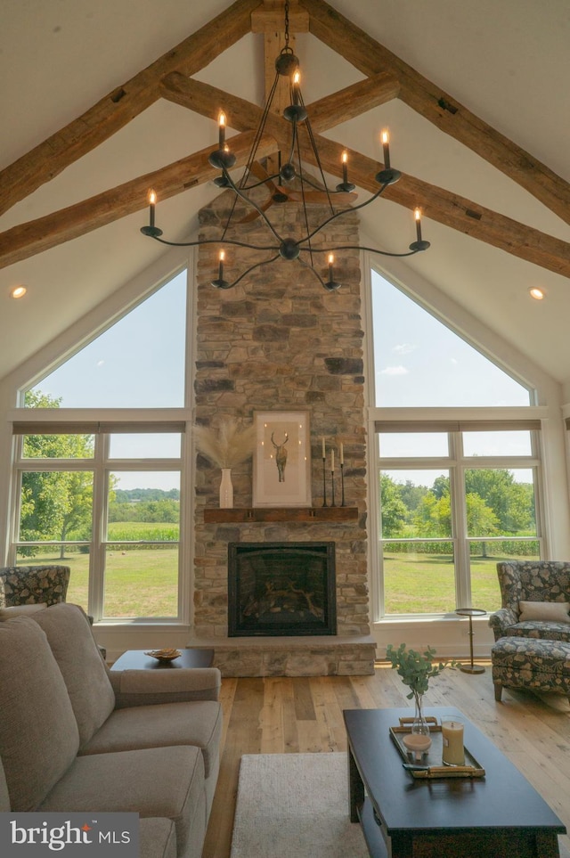 living room with beam ceiling, hardwood / wood-style flooring, a fireplace, and plenty of natural light