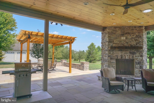 view of patio / terrace with a grill, a pergola, an outdoor stone fireplace, and ceiling fan