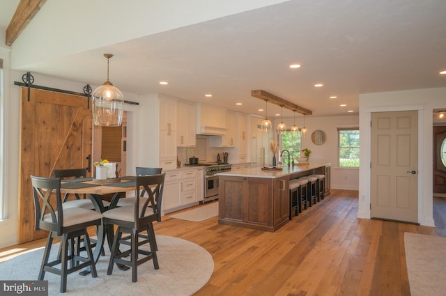 dining room featuring a barn door, sink, and light wood-type flooring