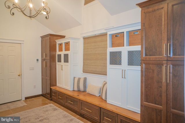 mudroom featuring lofted ceiling, light tile patterned floors, and an inviting chandelier