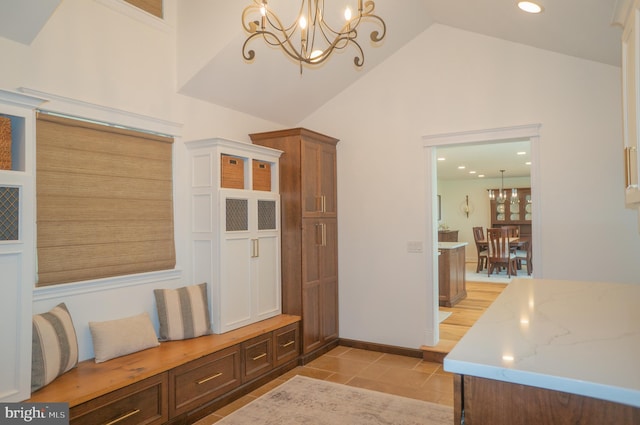 mudroom featuring an inviting chandelier, high vaulted ceiling, and light tile patterned flooring