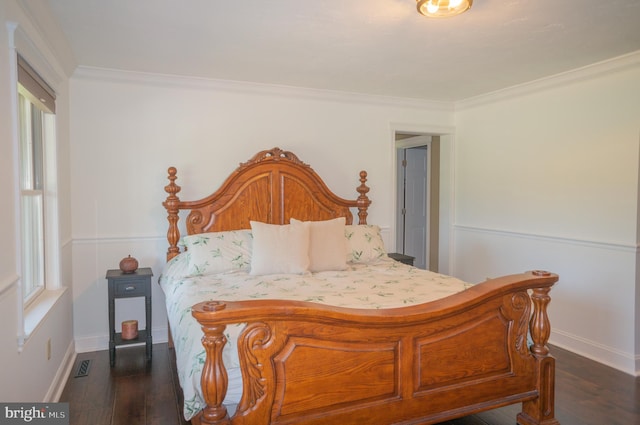 bedroom with crown molding and dark hardwood / wood-style floors