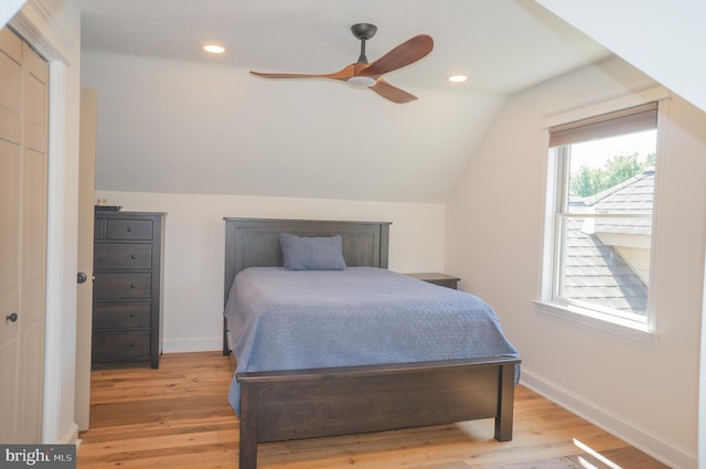 bedroom featuring ceiling fan, lofted ceiling, and light hardwood / wood-style flooring