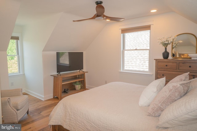 bedroom featuring multiple windows, lofted ceiling, ceiling fan, and light hardwood / wood-style flooring