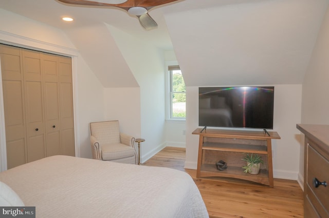 bedroom featuring ceiling fan, a closet, vaulted ceiling, and light hardwood / wood-style flooring